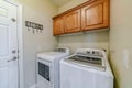 Laundry appliances inside small and functional utility room of residential home Royalty Free Stock Photo