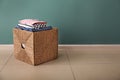 Laundry basket with folded clothes on floor near color wall Royalty Free Stock Photo