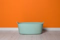 Laundry basket with handles near orange wall indoors, space for text Royalty Free Stock Photo