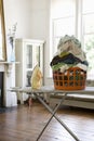 Laundry Basket And Iron On Ironing Board Royalty Free Stock Photo