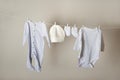 Laundry concept. Cleanliness, ironing, washing of children`s clothes. Baby things dry on a rope close-up and copy space on a gray