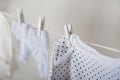 Laundry concept. Cleanliness, ironing, washing of children`s clothes. Baby things dry on a rope close-up and copy space on a gray