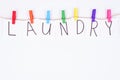 Laundry concept. Top above high angle view photo of letter and colorful clothespins hanging on rope isolated white wall