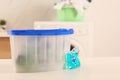Laundry container and washing detergent capsule on table indoors Royalty Free Stock Photo