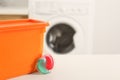 Laundry container and washing detergent capsule on table indoors. Space for text Royalty Free Stock Photo