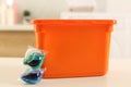 Laundry container and washing detergent capsules on table indoors Royalty Free Stock Photo