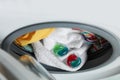 Laundry detergent capsules and clothes in washing machine drum, closeup view Royalty Free Stock Photo