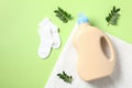 Laundry detergent gel bottle with green leaves and baby\'s socks on towel Royalty Free Stock Photo