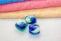 Laundry detergent pod for washing machine and colorful bath towels Royalty Free Stock Photo