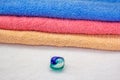 Laundry detergent pod for washing machine and colorful bath towels Royalty Free Stock Photo