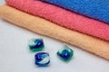 Laundry detergent pods for washing machine and colorful bath towels Royalty Free Stock Photo