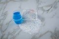 Laundry detergent powder and blue liquid gel in measuring cup Royalty Free Stock Photo