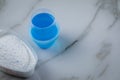 Laundry detergent powder and blue liquid gel in measuring cup Royalty Free Stock Photo
