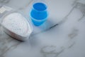 Laundry detergent powder and blue liquid gel in measuring cup Royalty Free Stock Photo