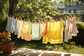 Laundry drying on clothesline in summer garden. Laundry day, After being washed, children\'s colorful clothing dries on a Royalty Free Stock Photo