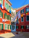 Laundry hanging out of typical houses of Burano Island, Venice, Italy. Multicolored buildings and laundry drying on the street in Royalty Free Stock Photo