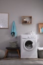 Laundry room interior with modern washing machine near light wall Royalty Free Stock Photo