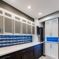 15 A laundry room with a mix of white and blue finishes, a large, graphic tile backsplash, and a mix of open and closed storage3