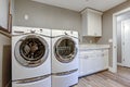 Laundry room with taupe walls and modern appliances.