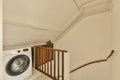 a laundry room with a washing machine and a staircase