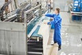 Laundry worker in the process of working on automatic machine for carpet washing