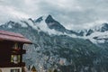 Lauterbrunnen, Switzerland, Jungfrau. Swiss Alps mountains. House with window shutters, flower boxes. Clouds, snow peaks Royalty Free Stock Photo