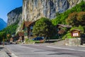 Lauterbrunnen village with chalets and high waterfall in background, Switzerland