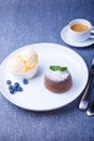 Lava cake - chocolate fondant cake with vanilla ice cream, blueberries, mint and coffee. Traditional French pastries. Close-up Royalty Free Stock Photo