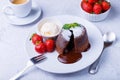 Lava cake - chocolate fondant cake with vanilla ice cream, strawberries, mint and coffee. Traditional French pastries. Close-up Royalty Free Stock Photo