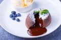 Lava cake with dripping filling. Chocolate fondant cake with vanilla ice cream, blueberries and mint. Traditional French pastries Royalty Free Stock Photo