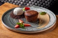 Lava cake with vanilla sauce with fresh strawberries, ice-cream ball Royalty Free Stock Photo