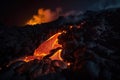 lava flow cascading down the side of a volcano, with orange and red flames visible in the night sky Royalty Free Stock Photo