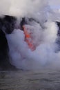 Lava flowing out of cliff suround with white cloud steam Royalty Free Stock Photo