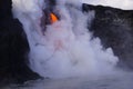 Lava flowing out of cliff suround with white cloud steam Royalty Free Stock Photo