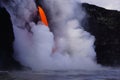 Lava flowing out of cliff suround with white cloud steam Royalty Free Stock Photo