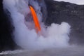 Lava flowing out of cliff suround with white cloud steam Royalty Free Stock Photo