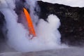 Lava flowing out of cliff suround with white cloud steam Royalty Free Stock Photo