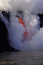 Lava flowing out of cliff suround with white cloud steam Royalty Free Stock Photo