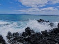 Lava Rock and Coral with Spray of crashing wave in tide pools at Maluaka Beach and Kihei Maui with sky and clouds Royalty Free Stock Photo