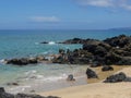 Lava Rock and Coral with Spray of crashing wave in tide pools at Maluaka Beach and Kihei Maui with sky and clouds Royalty Free Stock Photo