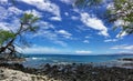 Lava Rock and Coral with Spray of crashing wave in tide pools at Maluaka Beach and Kihei Maui with sky and clouds Royalty Free Stock Photo