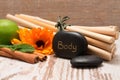 Lava stone with the inscription BODY, bamboo and marigold Royalty Free Stock Photo