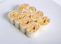 Lavash roll with fish and egg filling on white plate