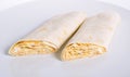 Lavash roll with fish and egg filling on white plate