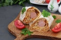 Lavash roll with sausage and stewed cabbage on wooden board Royalty Free Stock Photo