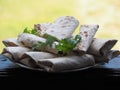 Lavash rolls on a plate with herbs.