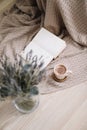 Lavender bouquet with book and cup of coffee on wooden background. spring concept. top view. flatlay