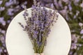 Lavender bouquet on a wooden bench in lavender field