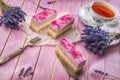 Lavender cake served on pink background with flowers and cup of tea, vintage background with cake