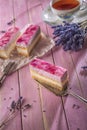 Lavender cake served on pink background with flowers and cup of tea, vintage background with cake